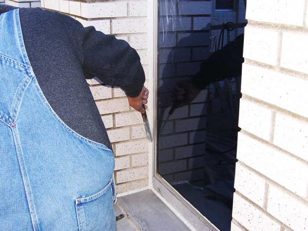 Crew Member finishing the Caulking on a Window