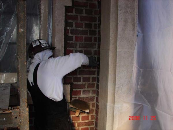 Brick Mason Repairing a Brick Wall