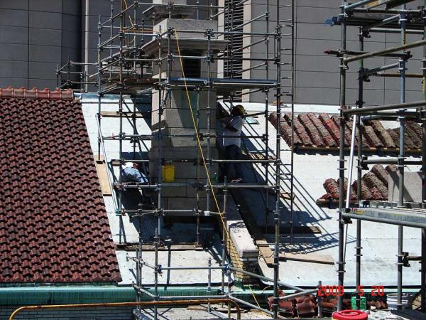 Brick Masons Repairing a Building