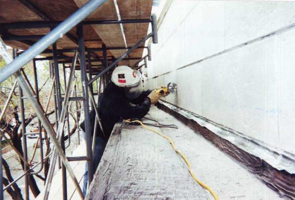 Crew Member Repairing Stone Building